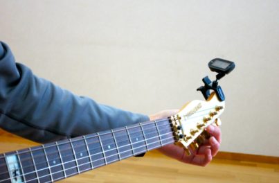 ギターネックを調整する男性